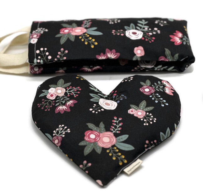 combo of a neckwrap and hearth shaped eye pillow with a black fabric with flower pictures